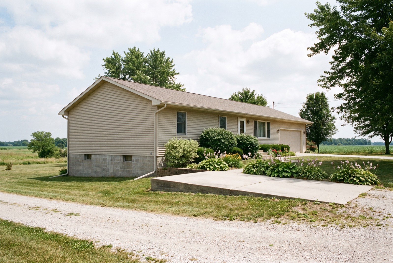A manufactured home on a permanent foundation with an attached garage and a concrete driveway